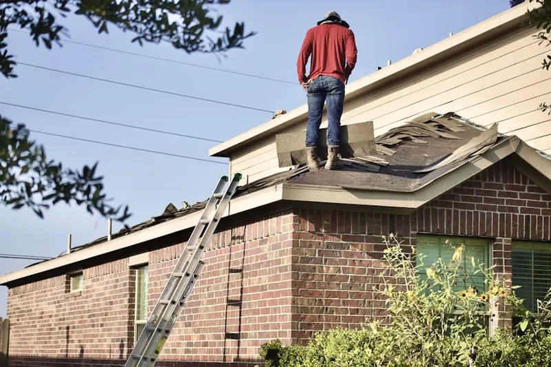 Professional roofer working on a residential roof in Collamer